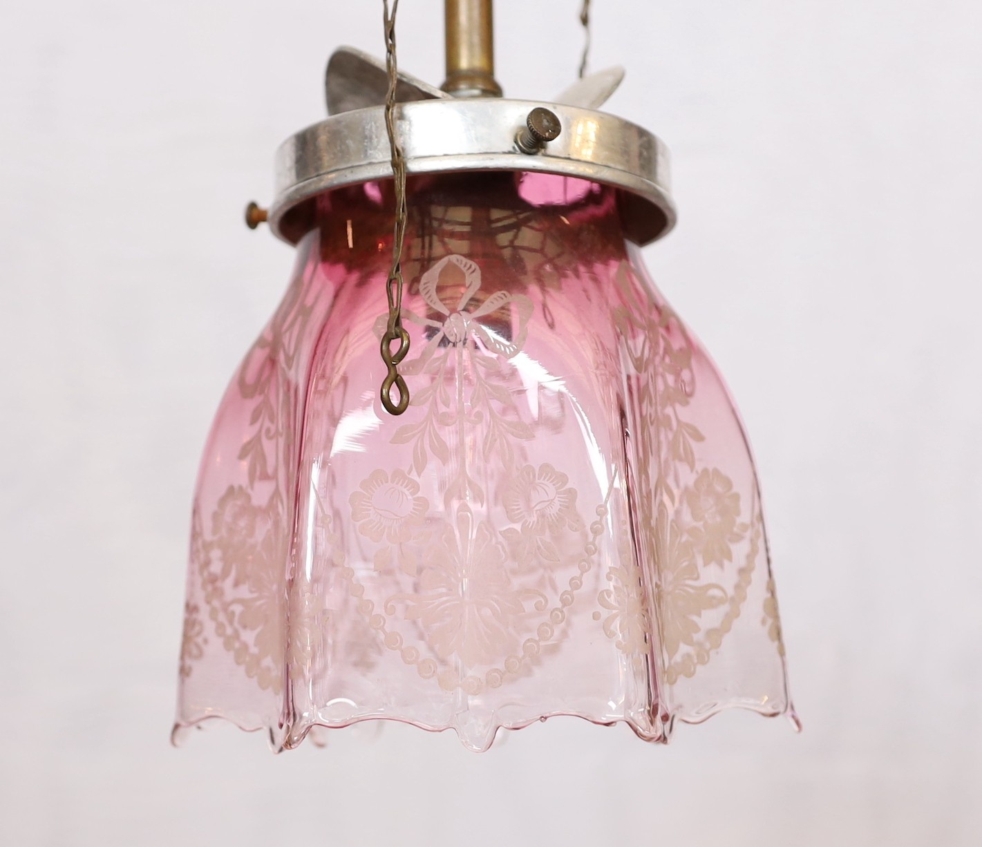 An early 20th century English brass gasolier light fitting, converted to electricity, with pink tinted etched glass shade, height 50cm